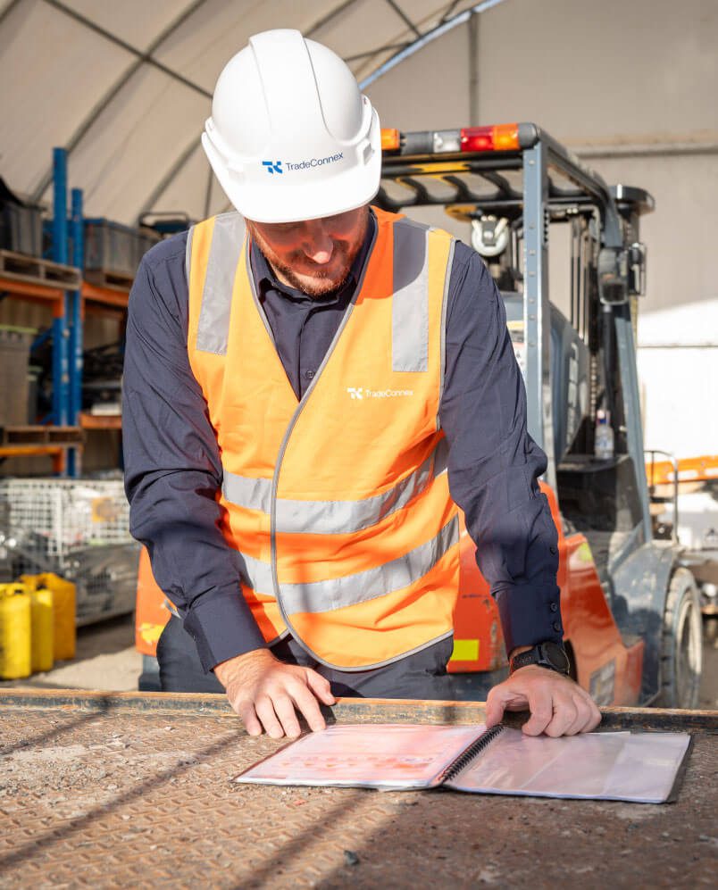 Worker from Tradeconnex on site reviewing plans