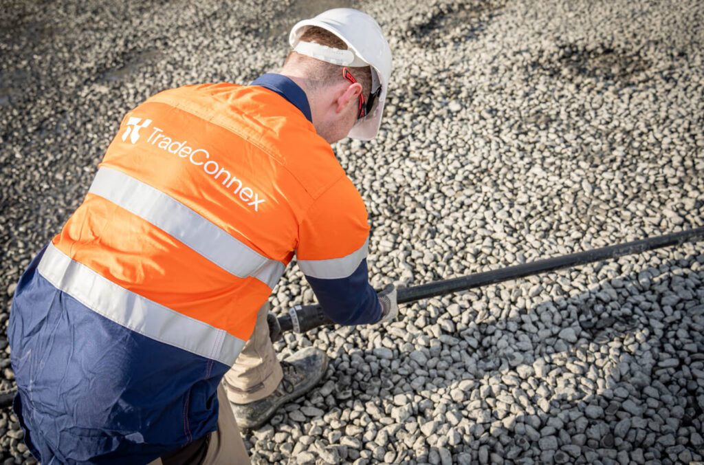 Worker from Tradeconnex on site connecting hoses