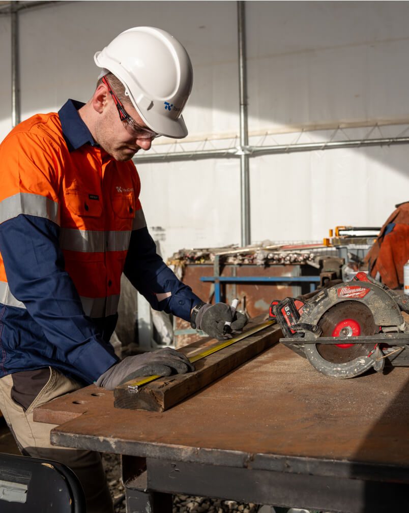 Carpenter from Tradeconnex measuring wood on site to be cut