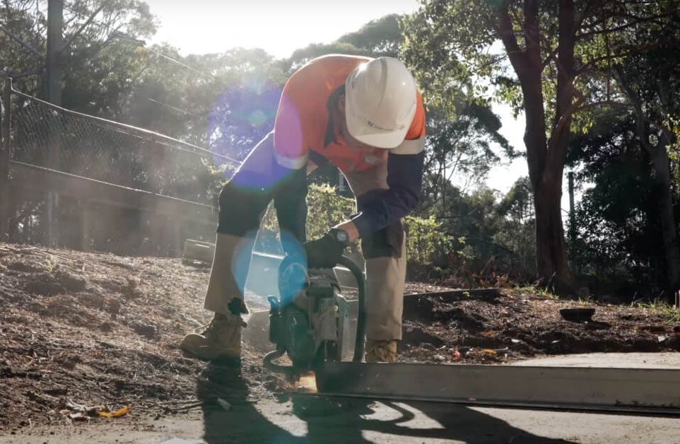 Construction worker operating a concrete saw on a job site